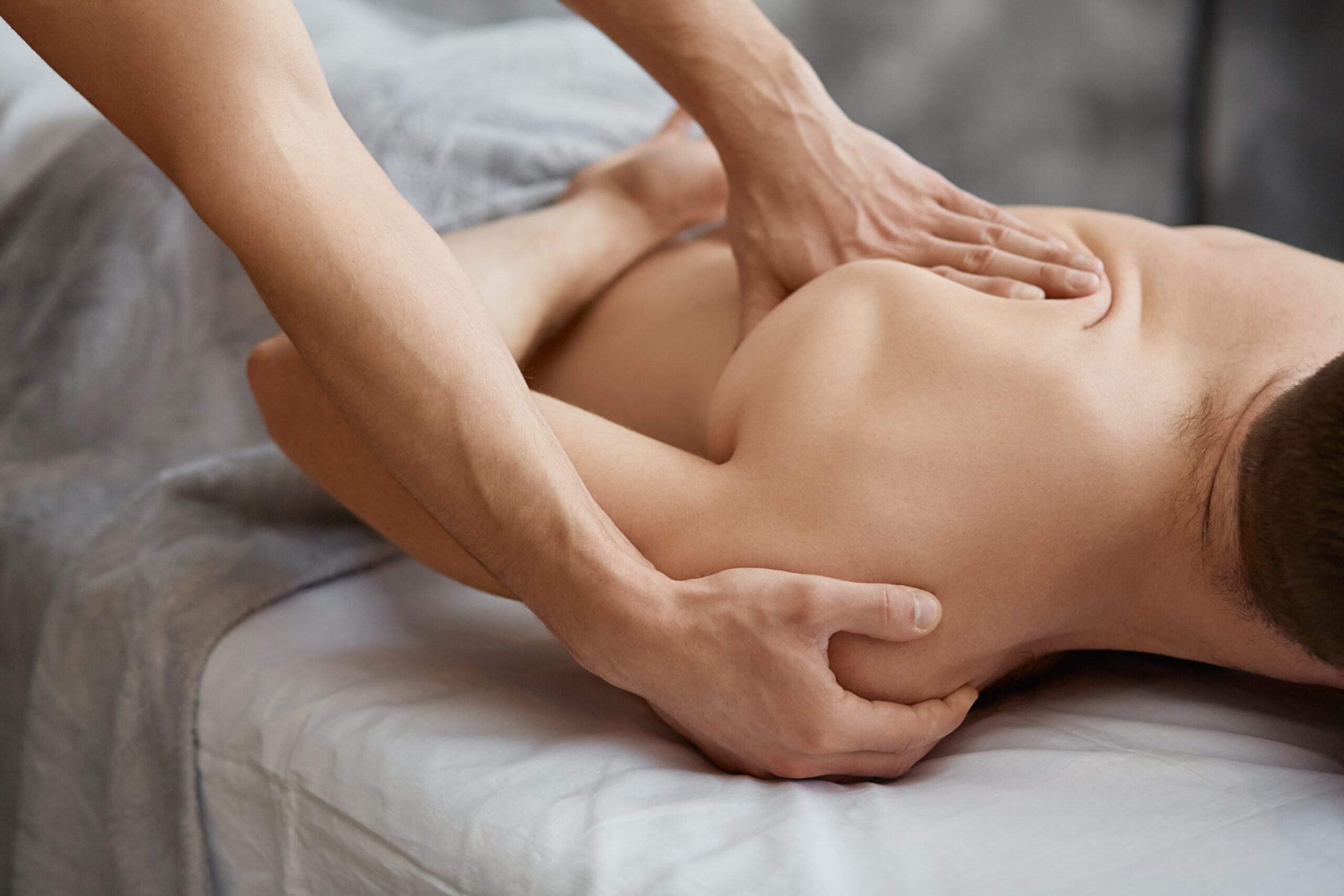 Young Handsome Man Enjoying A Back Massage. Professional Massage